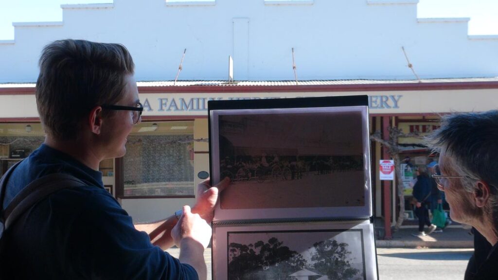 Samuel Doering shows a comparison photo of the store which is now occupied by the Heritage Gallery